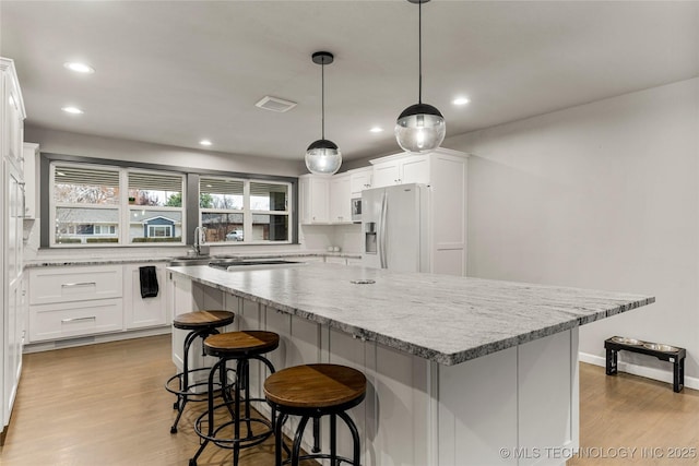 kitchen with appliances with stainless steel finishes, a kitchen island, and white cabinets