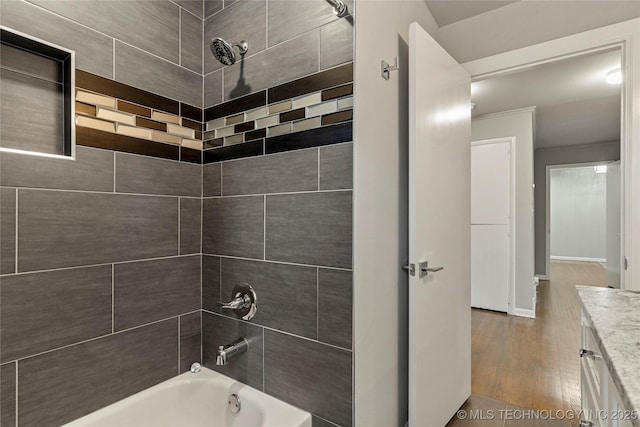 bathroom with vanity, wood-type flooring, and tiled shower / bath