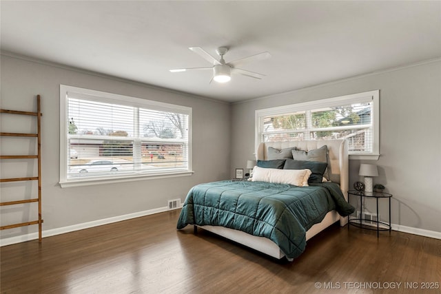 bedroom with multiple windows, crown molding, and dark hardwood / wood-style flooring