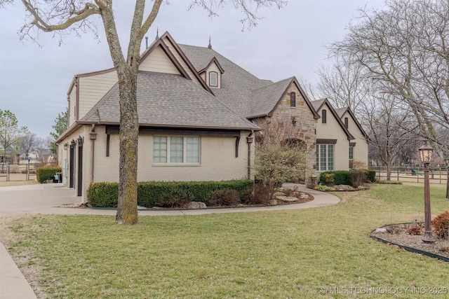 tudor-style house featuring a garage and a front yard