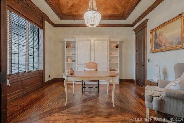 office area featuring dark wood-type flooring, crown molding, a raised ceiling, and an inviting chandelier