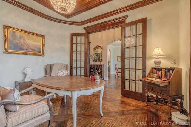 dining space with a notable chandelier, ornamental molding, and french doors