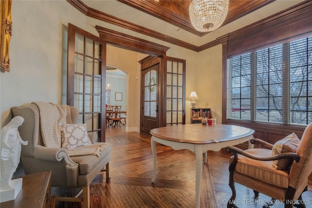 dining space with crown molding, a chandelier, french doors, and hardwood / wood-style flooring