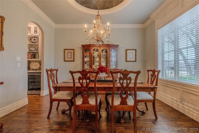 dining area featuring ornamental molding, dark hardwood / wood-style floors, beverage cooler, and built in shelves