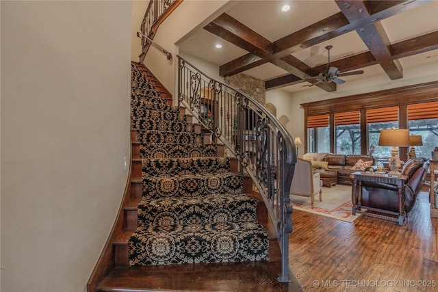 stairs with ceiling fan, coffered ceiling, hardwood / wood-style floors, and beam ceiling