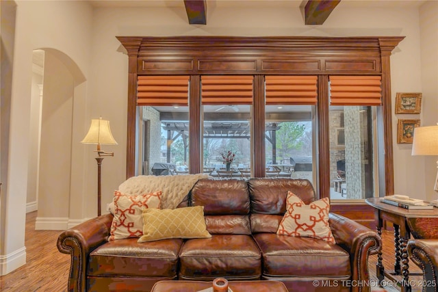 living room featuring beamed ceiling and light wood-type flooring