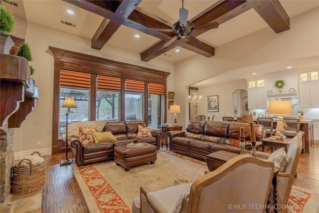 living room featuring coffered ceiling, beam ceiling, and light hardwood / wood-style flooring