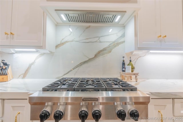 kitchen featuring extractor fan, stainless steel gas cooktop, white cabinets, and light stone counters