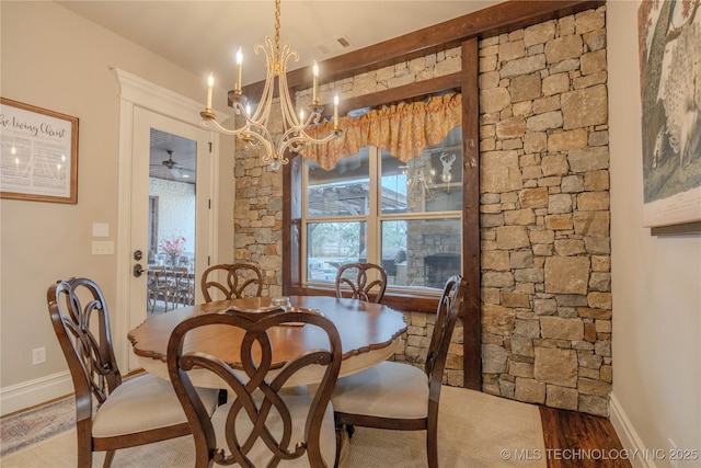 dining area featuring wood-type flooring and ceiling fan with notable chandelier