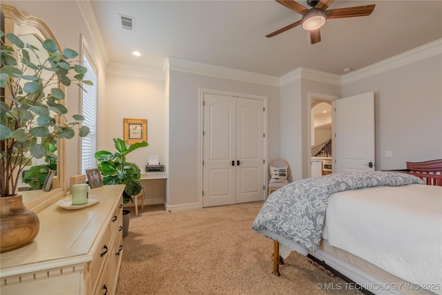 bedroom with ornamental molding, light colored carpet, ceiling fan, and a closet