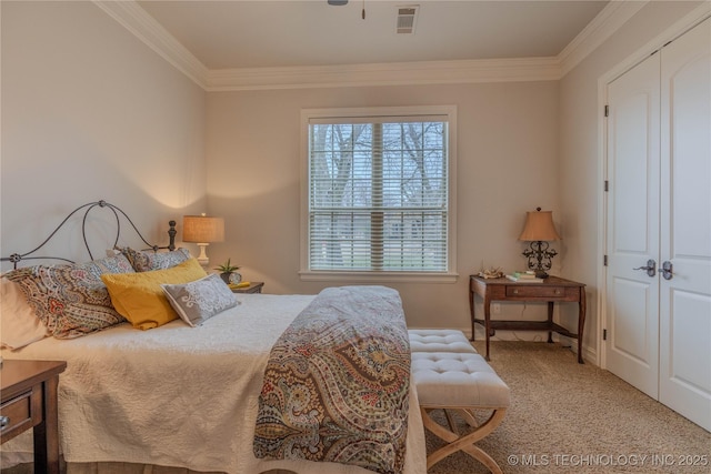 carpeted bedroom with crown molding and a closet