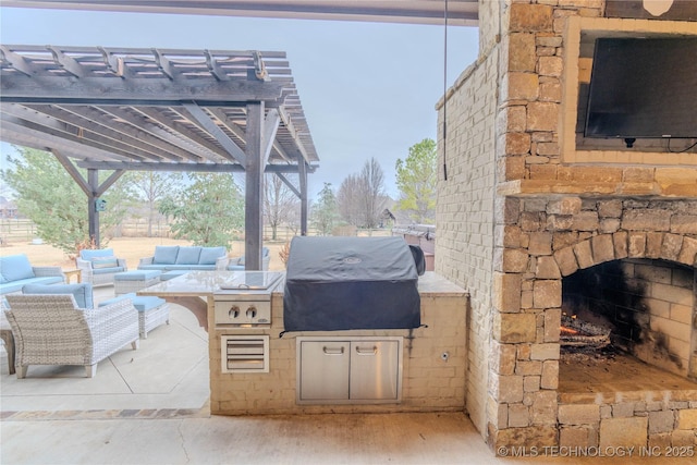 view of patio featuring exterior kitchen, an outdoor living space with a fireplace, grilling area, and a pergola