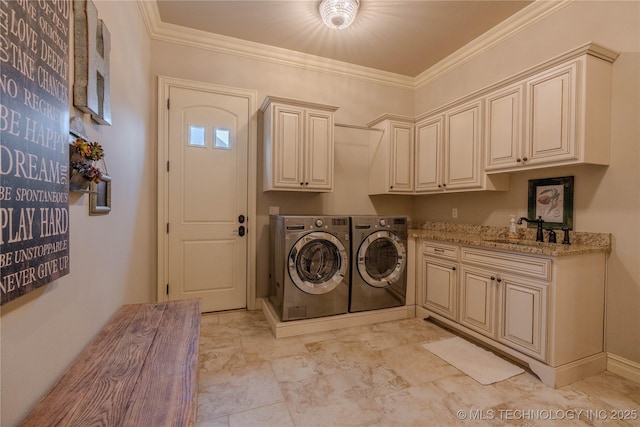 laundry area with sink, ornamental molding, cabinets, and washing machine and clothes dryer