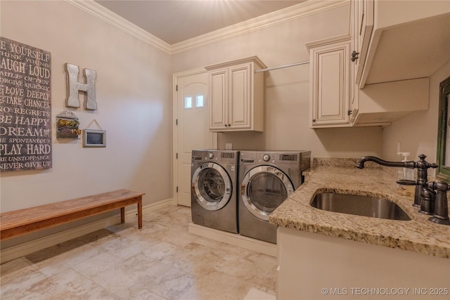 laundry area with cabinets, ornamental molding, sink, and washing machine and dryer