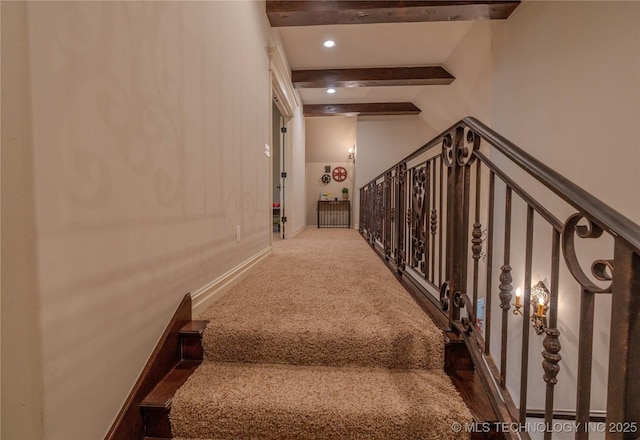 staircase with carpet flooring and vaulted ceiling with beams