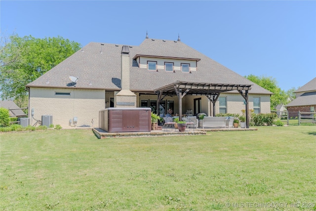 back of house with central AC unit, a pergola, a patio area, a yard, and a hot tub
