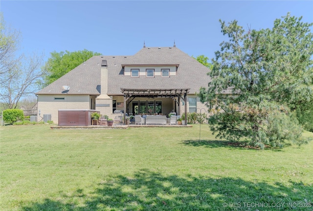 rear view of property featuring a yard, a patio area, a pergola, and a hot tub