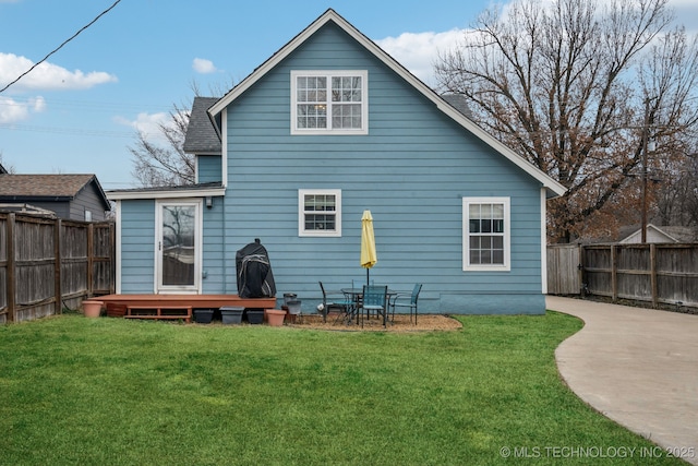 back of house with a patio and a lawn