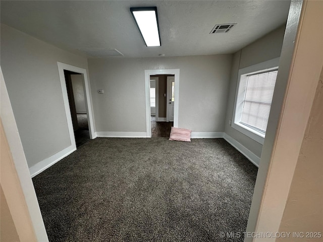 carpeted spare room featuring a textured ceiling