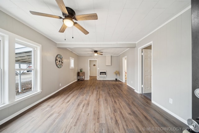 unfurnished living room featuring heating unit and wood-type flooring