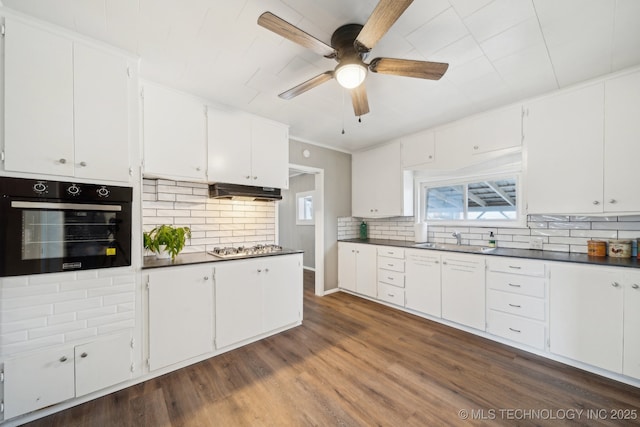 kitchen featuring sink, dark wood-type flooring, oven, and white cabinets