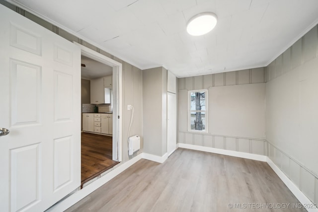 unfurnished room featuring crown molding and light hardwood / wood-style flooring