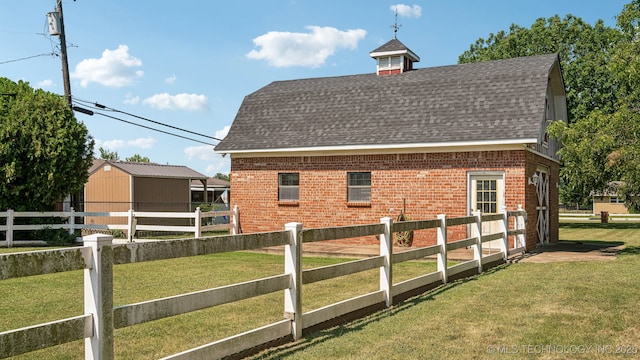 view of home's exterior with an outbuilding and a yard