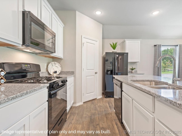 kitchen with dark wood-type flooring, sink, light stone counters, black appliances, and white cabinets