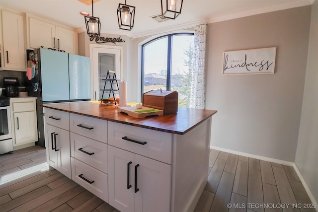 kitchen with white cabinets, pendant lighting, and wooden counters