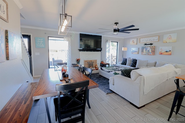 living room with ornamental molding, ceiling fan, a fireplace, and light hardwood / wood-style flooring