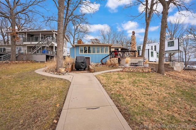 view of front facade featuring a wooden deck and a front yard