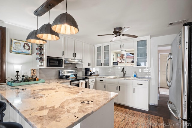 kitchen featuring appliances with stainless steel finishes, white cabinetry, hanging light fixtures, light stone counters, and kitchen peninsula