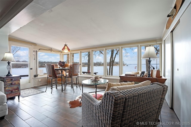 sunroom / solarium featuring a water view and lofted ceiling