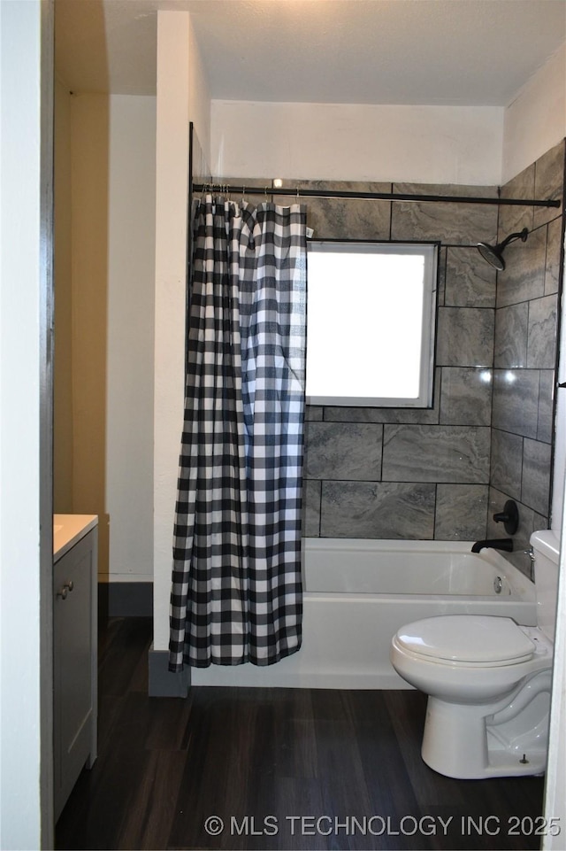 full bathroom featuring vanity, hardwood / wood-style floors, shower / tub combo with curtain, and toilet