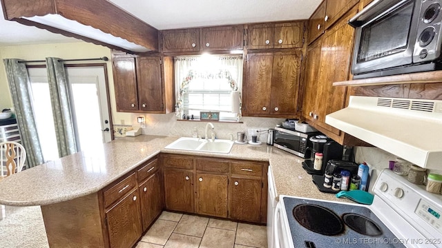 96848 S 4510th Rd, Vian, OK 74962 - kitchen with range, a sink, stainless steel microwave, a peninsula, and light countertops