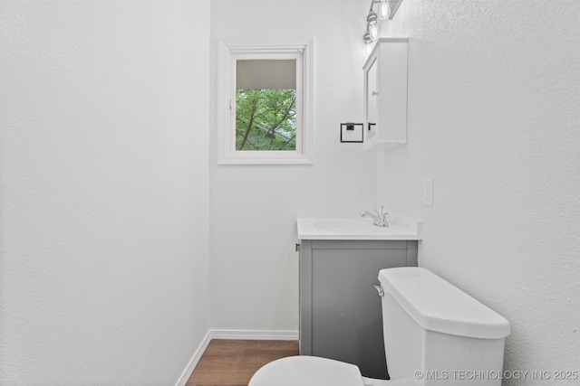 501 W 17th St, Pawhuska, OK 74056 - bathroom with toilet, vanity, baseboards, and wood finished floors