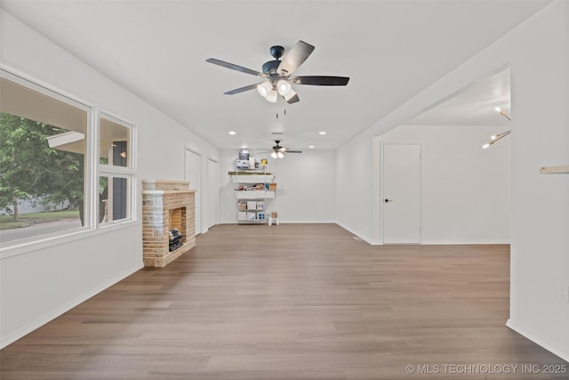 501 W 17th St, Pawhuska, OK 74056 - unfurnished living room with a brick fireplace, baseboards, ceiling fan, wood finished floors, and recessed lighting
