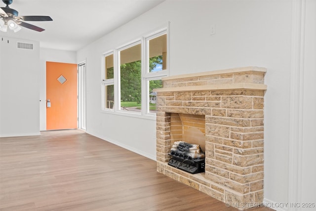 501 W 17th St, Pawhuska, OK 74056 - unfurnished living room featuring a ceiling fan, wood finished floors, baseboards, and a fireplace