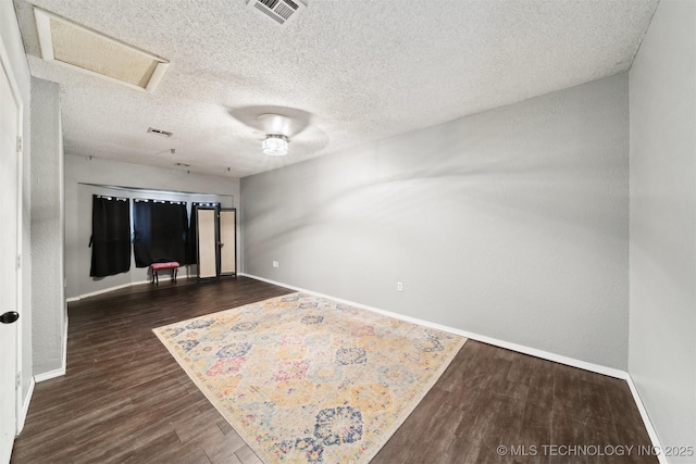 unfurnished room with dark hardwood / wood-style floors and a textured ceiling