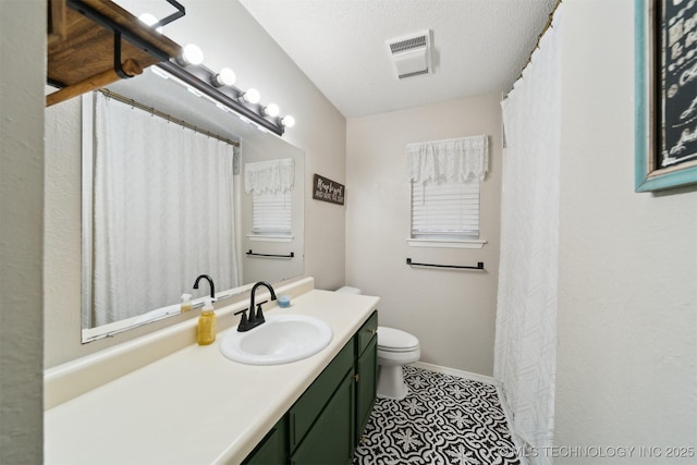 bathroom with vanity, a textured ceiling, and toilet