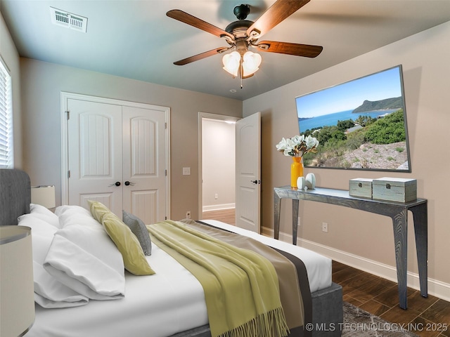 bedroom featuring ceiling fan, dark hardwood / wood-style floors, and a closet