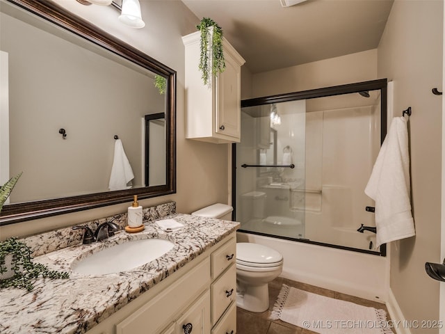 full bathroom featuring tile patterned flooring, vanity, shower / bath combination with glass door, and toilet