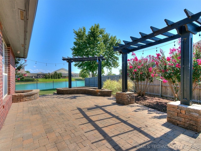 view of patio with a pergola and a water view