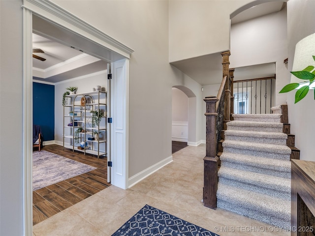 foyer featuring crown molding, ceiling fan, a raised ceiling, and light hardwood / wood-style floors