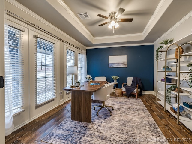 office area featuring dark hardwood / wood-style flooring, a tray ceiling, ornamental molding, and ceiling fan