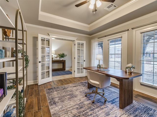 office space with dark hardwood / wood-style floors, a tray ceiling, plenty of natural light, and french doors