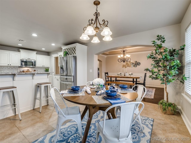 tiled dining room featuring an inviting chandelier