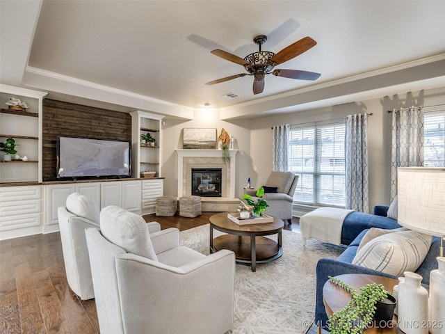 living room with ceiling fan, ornamental molding, a healthy amount of sunlight, and hardwood / wood-style floors