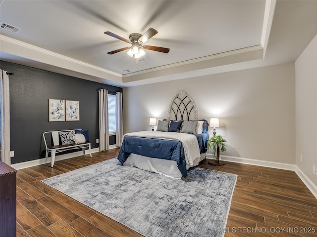 bedroom featuring crown molding, ceiling fan, a tray ceiling, and dark hardwood / wood-style flooring