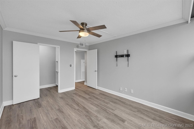 unfurnished bedroom with ornamental molding, light hardwood / wood-style flooring, and a textured ceiling